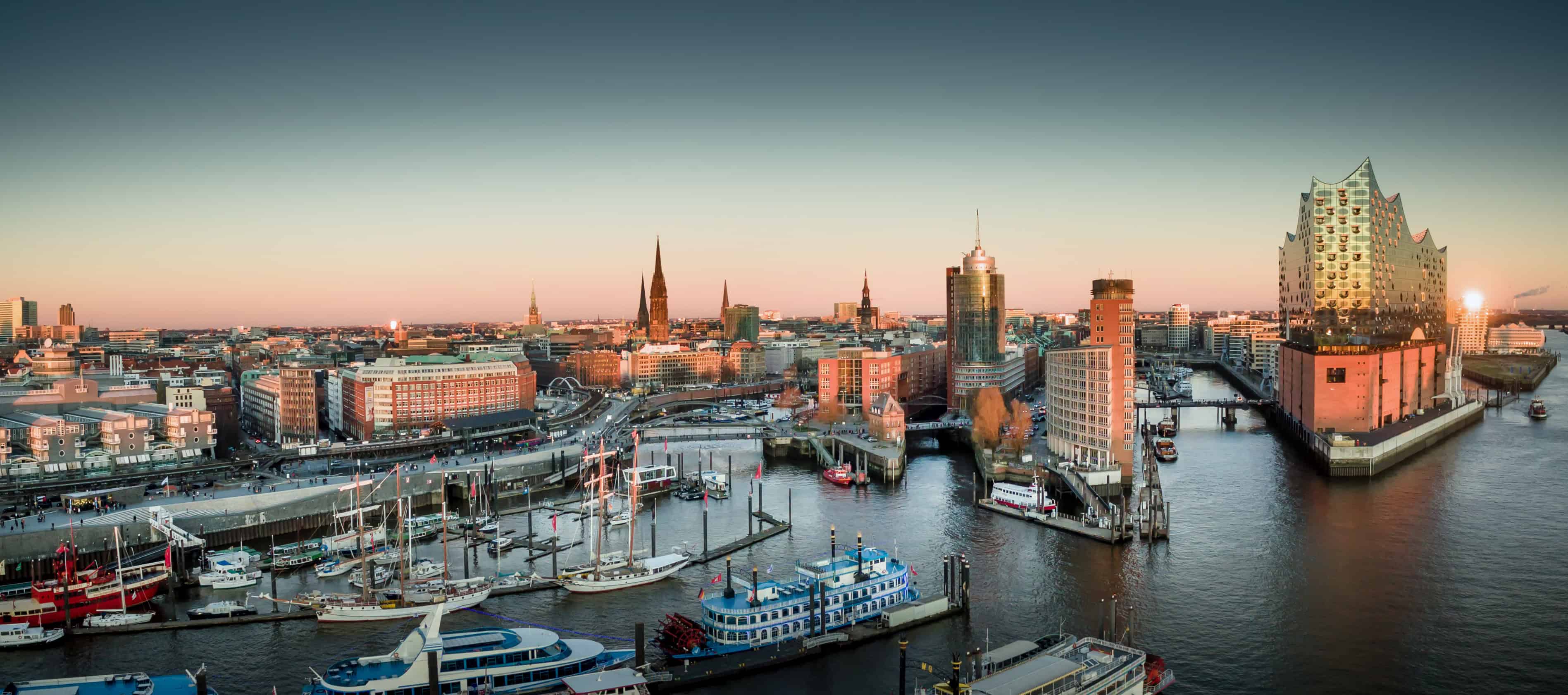 Hafen Hamburg mit modernen Gebäuden und Wasserblick bei Sonnenuntergang, Immobilien in Hamburg.
