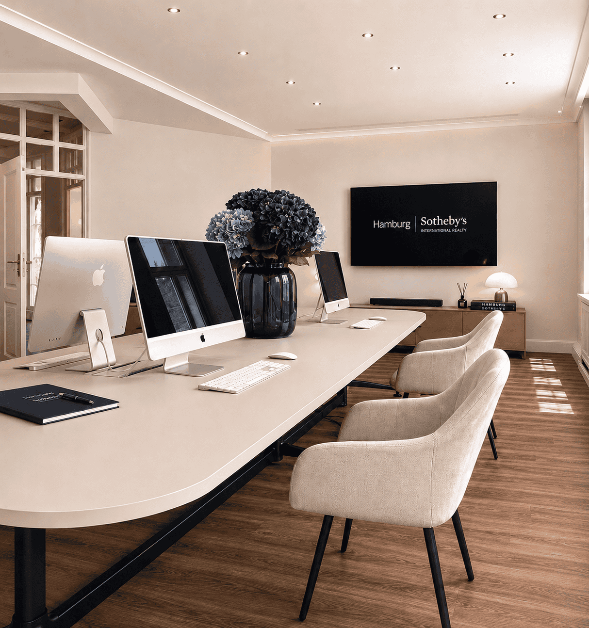 Hochwertiges Büro mit Apple-Computern, Blumen und moderner Ausstattung in Hamburg.