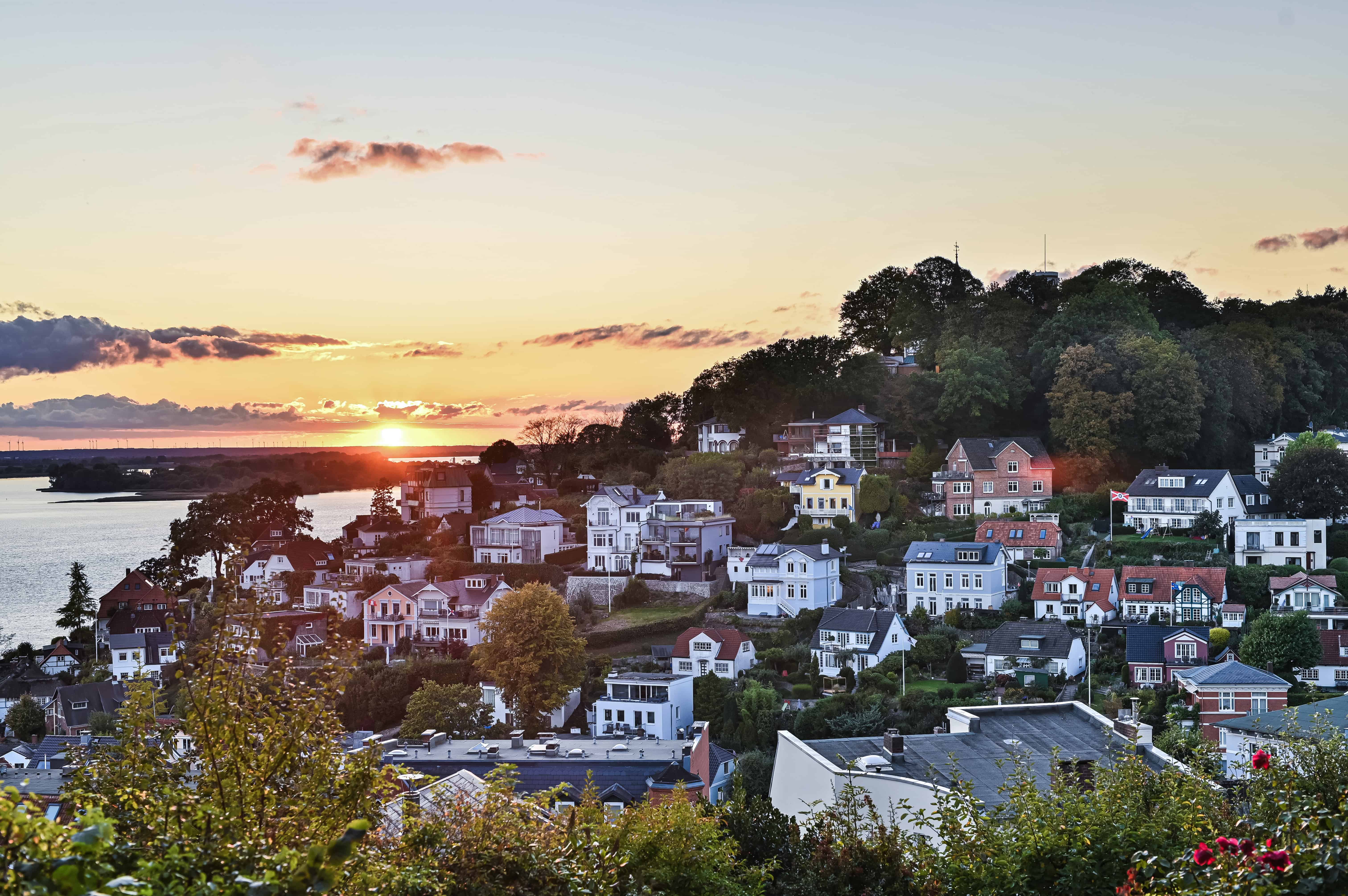 Häuser am Wasser in Hamburg bei Sonnenuntergang, Immobilien in Hamburgs Vororten.