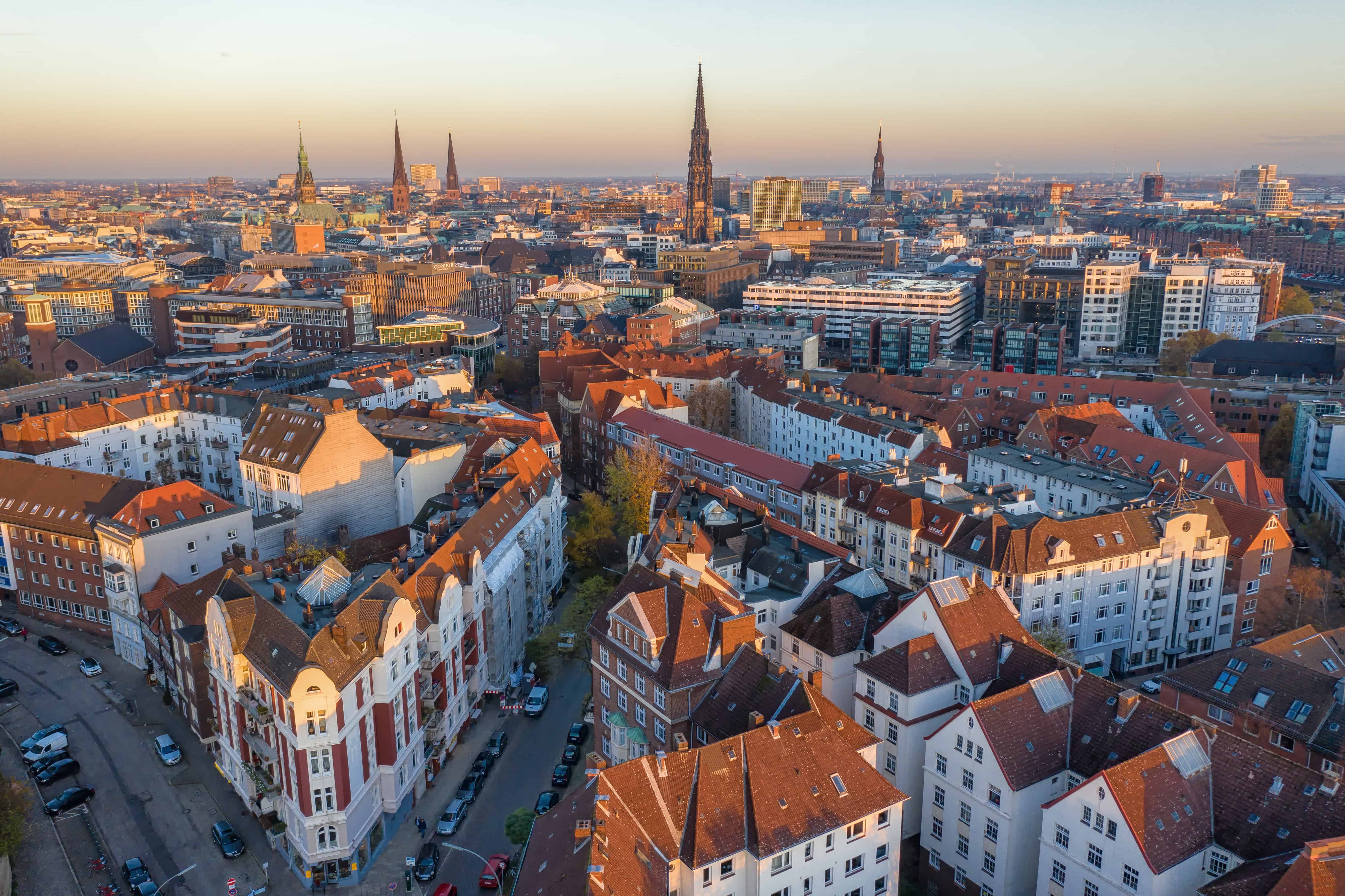 High-quality aerial view of Hamburg's city center with historic buildings and church spires in the sun.