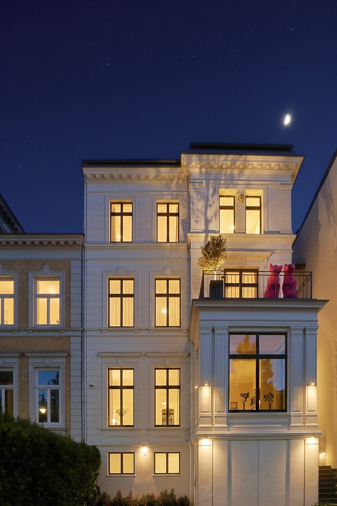 Elegantes Haus in Harvestehude bei Nacht mit beleuchteten Fenstern.