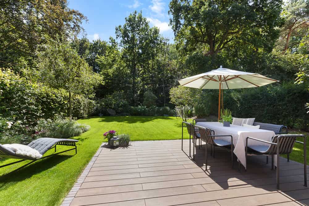 Moderne Terrasse mit Garten, Sonnenschirm und Sitzbereich in Blankenese.