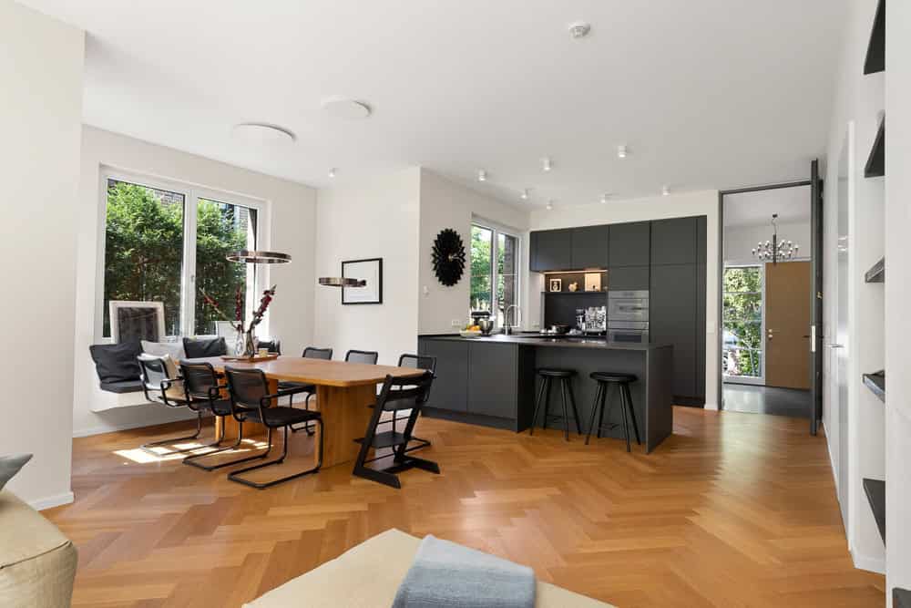 Helles, modernes Wohnzimmer mit offener Küche und großen Fenstern in Blankenese.