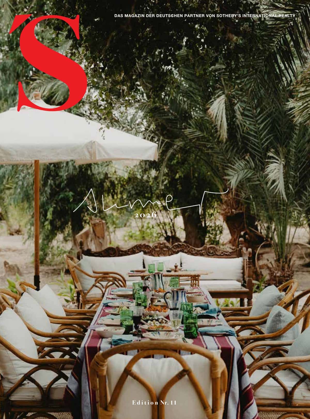 Elegant garden table in a tropical garden with seating and parasol.